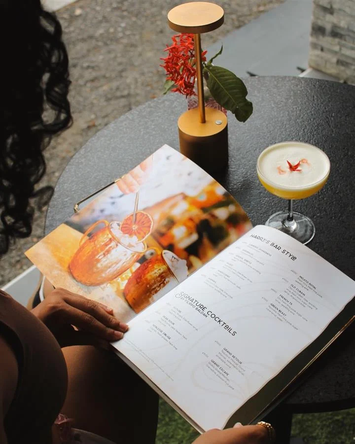Guest reading the cocktail list with drinks on the table